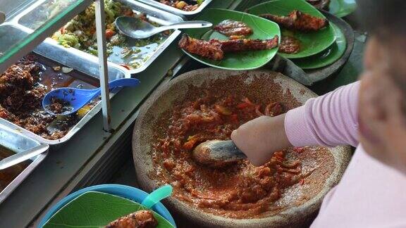 亚洲街头小贩用研钵和杵制作番茄酱