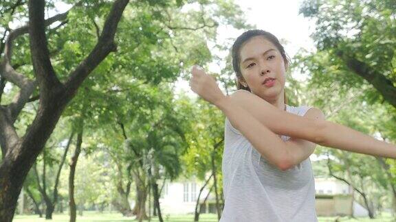 运动的年轻亚洲女人热身和伸展运动前在日出在一个公园运动健康的生活理念
