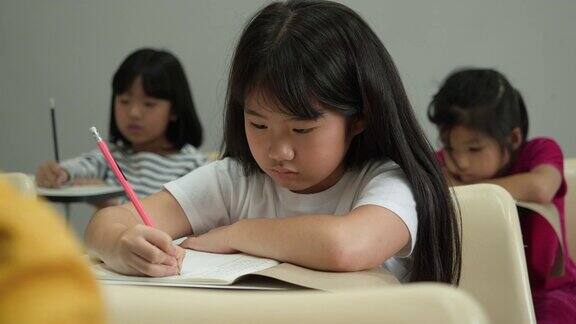 亚洲孩子对学习不感兴趣在学校的教室里懒惰和困倦教育