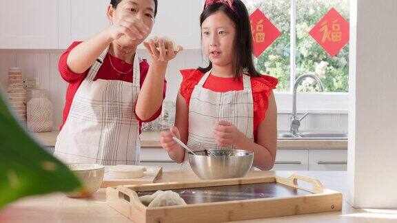 做饭学习和亚洲与母亲和女孩在厨房为中国农历新年节日美食快乐和帮助妈妈和孩子用饺子文化健康和微笑的家庭