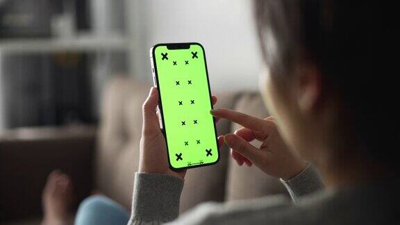 女人在用绿色屏幕的智能手机