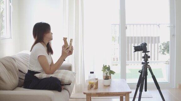 亚洲女性博主用摄影机录下录像并在家中大声发言