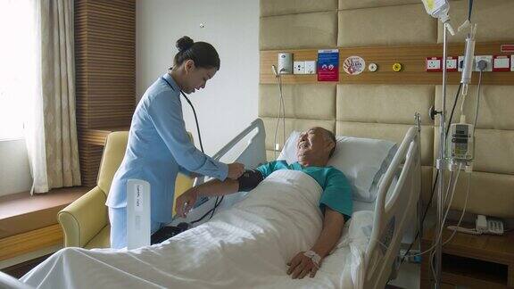 亚洲护士在医院检查老人血压的实时视频
