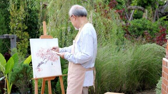 老人画画老人在花园里画画老人在白纸上拿着彩绘画老人在空闲时间活动快乐的老人有退休后的生活理念