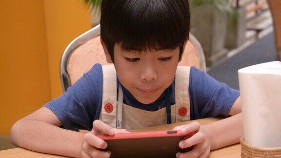 亚洲男孩在玩手机游戏