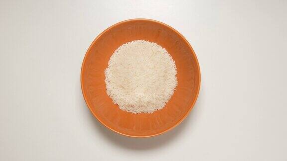 俯视图:白色米饭装满一个棕色的盘子(定格)