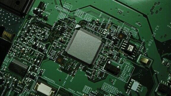 专注于微芯片CPU处理器绿色印刷电路板计算机主板与元件:电子设备内部超级计算机的一部分旋转俯视图跟踪微距拍摄