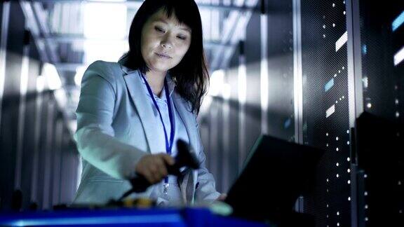 亚洲女性IT工程师工作在一个应急车笔记本电脑她扫描硬盘她在满是机架服务器的大数据中心
