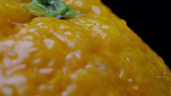 微距摄影近景闪亮斑点表面的一个橙子与水露