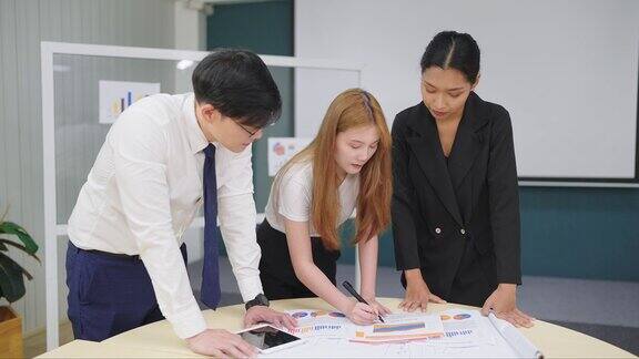 三个年轻的商人在办公室的会议室里集思广益计划公司的财务策略一群亚洲员工在会议上交谈和讨论商务会议概念