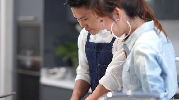 亚洲年轻夫妇在厨房做饭