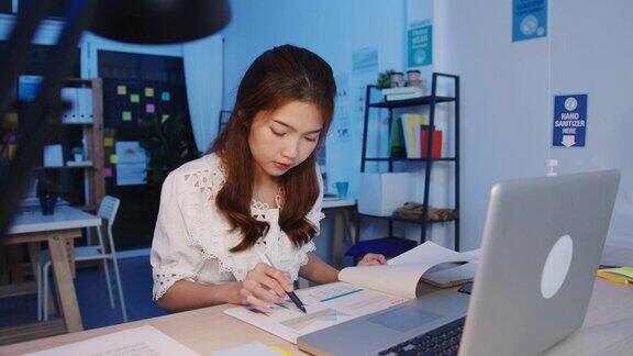 自由亚洲女性使用笔记本电脑努力工作在新的正常的家庭办公室