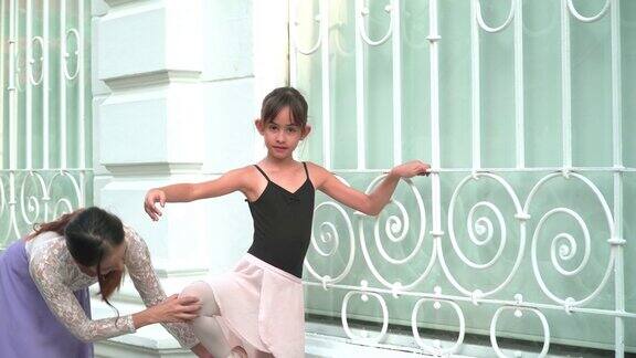 一位亚洲青少年芭蕾舞者在泰国曼谷的一条当地街道上练习芭蕾舞年轻的女芭蕾舞教师概念活泼的年轻妇女和孩子在周末的活动