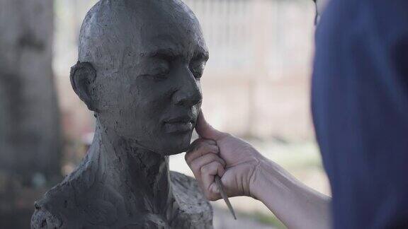 亚洲人雕塑家创造一个泥塑