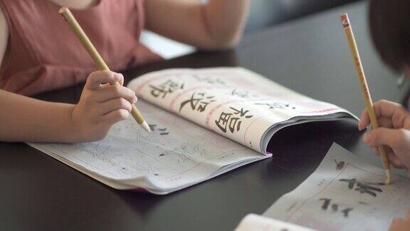 亚洲华人兄弟姐妹在家里练习书法