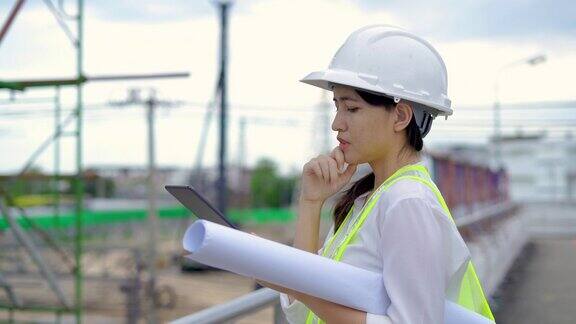 女土木工程师在工地用平板检查建筑师图纸