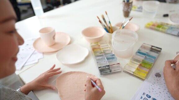 4K亚洲妇女设计模式绘画自制陶瓷板在陶艺工作室