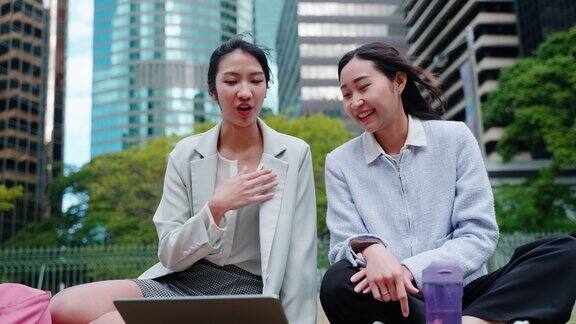 两个亚洲女学生聚在一起使用笔记本电脑进行在线学习