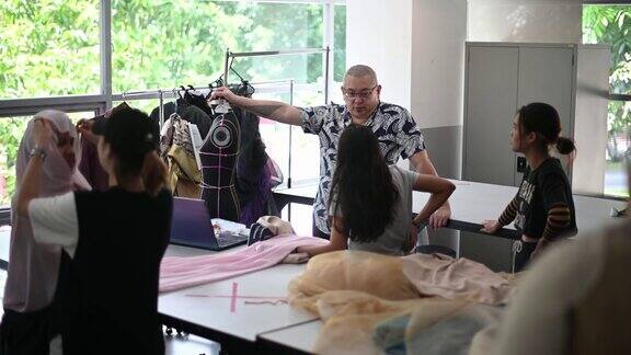 亚洲学院的时装老师和学生在课堂上进行他们的时装设计项目