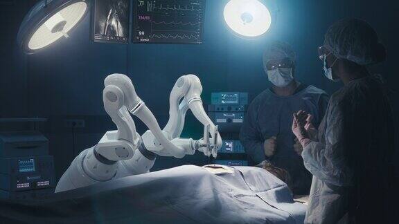 两名外科医生在未来医院观察高精度可编程自动机器人手臂为病人手术机器人四肢进行先进的纳米手术医生在监视器上观察生命体征