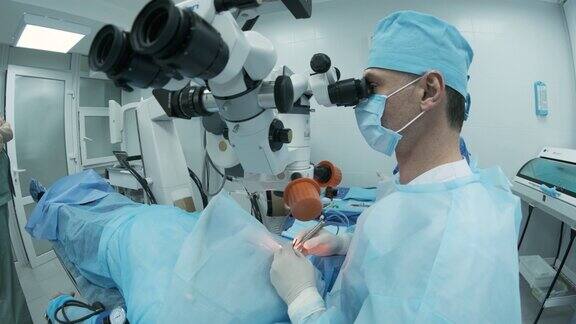 外科医生在手术室里用显微镜观察女病人的眼睛医生在眼科手术、白内障治疗和屈光度矫正过程中使用显微镜