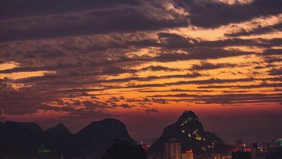 在中国广西柳州夕阳中的建筑和山丘的4K延时摄影