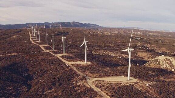 航拍的风车涡轮机旋转创造自然风能在山区