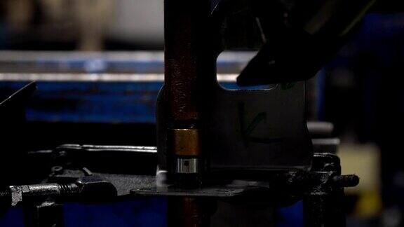 工业工人正在用点焊机将螺母焊接到金属零件上