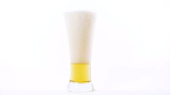 特写把啤酒倒进白色背景的杯子里