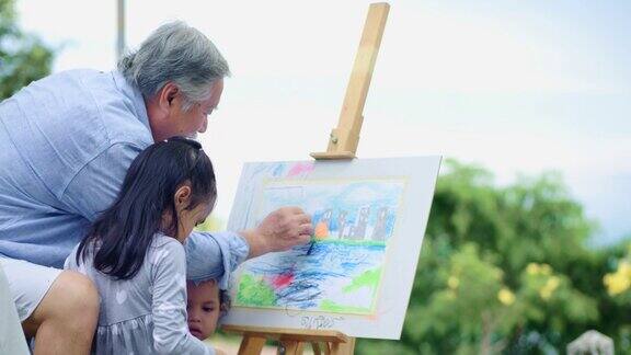 亚洲爷爷和孙女在公园里玩着色游戏