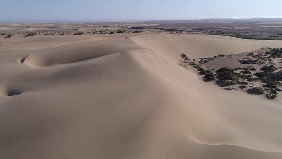 4K沙丘鸟瞰图与稀疏的植被在纳米布沙漠骨骼海岸纳米比亚