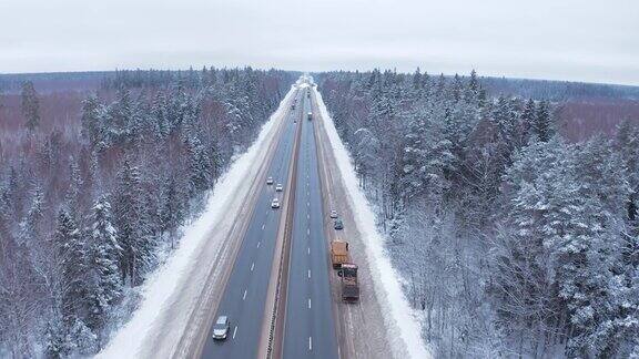 两辆卡车和一辆轿车停在路边一辆警车在高速公路上的雪林中发生了事故