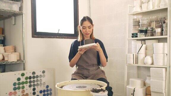 4K亚洲女雕刻家艺术家在陶瓷工作室的陶瓷车轮上造型陶器