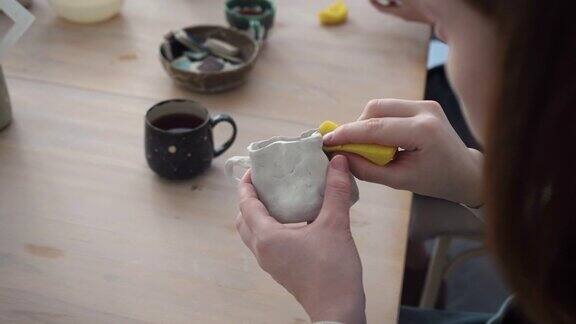 陶器匠用未加工的粘土制作杯子制造陶瓷手工陶艺店