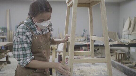 木工车间里用锯子锯木头的女木匠