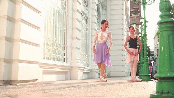 在泰国一个阳光明媚的日子里一名亚洲青少年芭蕾舞者在曼谷的街道上练习芭蕾舞动作和当芭蕾舞老师的年轻女子一样概念活泼的年轻妇女和孩子在周末的活动