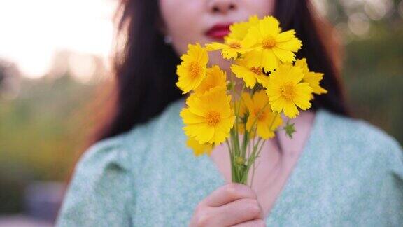 女人手里拿着黄色的花