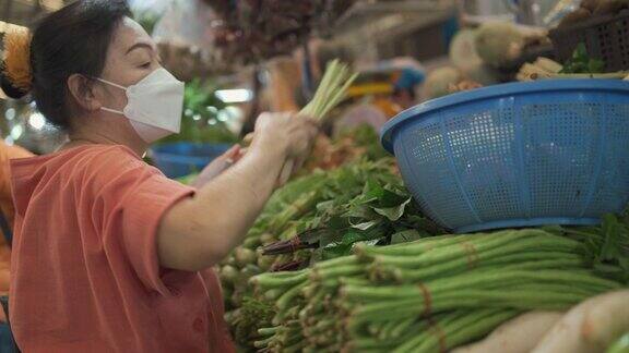 购买蔬菜的亚洲老年妇女