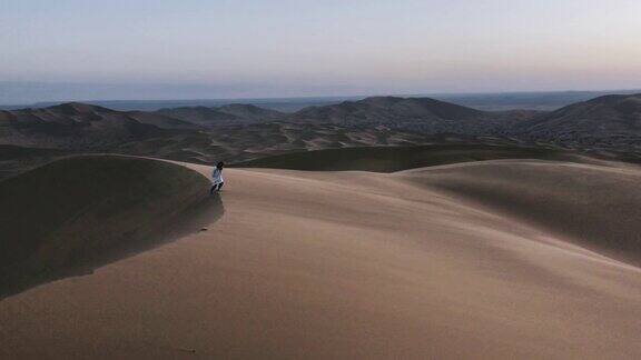 一个摩洛哥男人走在摩洛哥多风的沙漠中