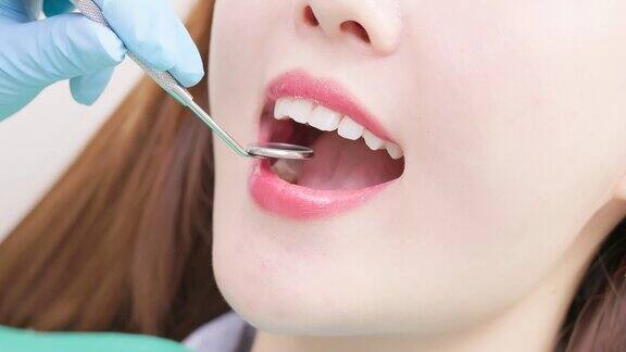 牙医检查亚洲妇女的牙齿