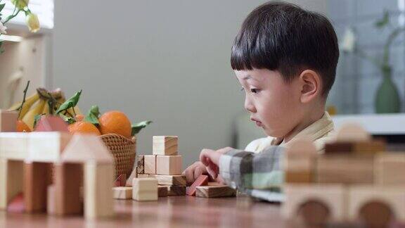 一个亚洲男孩在桌子上玩积木