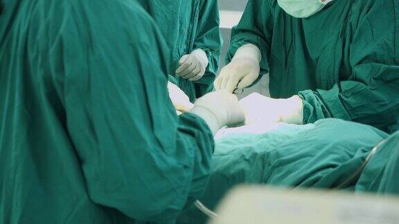 多民族外科手术组穿着防护服在医院手术室进行手术医疗队在现代手术室进行手术
