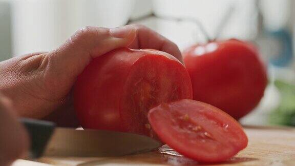 厨师正在切西红柿他用一把刀在一块黑板上切