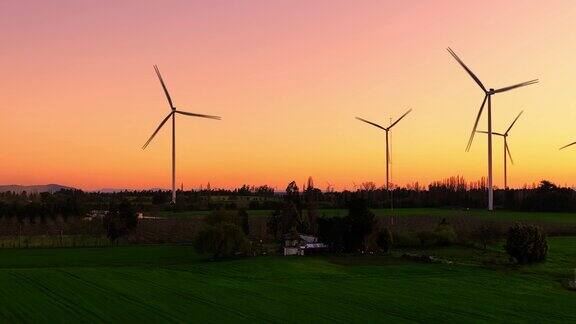 夕阳下的风力涡轮机农场鸟瞰图可再生能源生产无人机视频