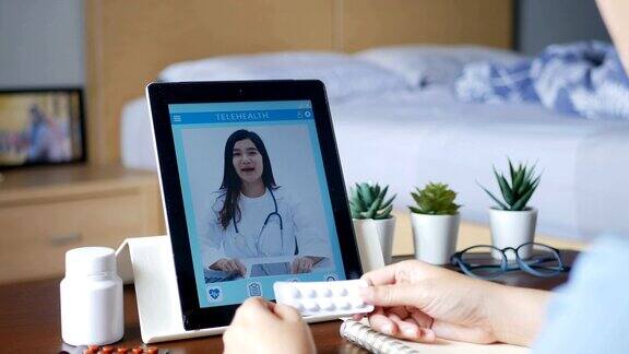 4k女病人使用视频会议通过平板电脑与医生进行在线咨询患者通过视频电话向医生询问病情和药物远程保健、远程医疗和在线医院