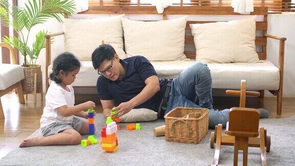 4K亚洲父亲和小女儿在家里玩木制玩具
