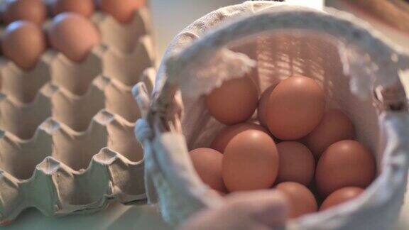 亚洲中国妇女手把鸡蛋从鸡蛋盒放入篮子在家里