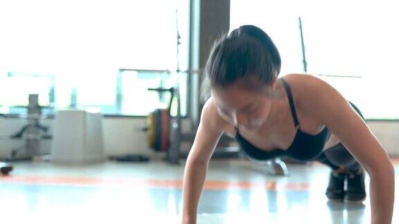 专业美丽的亚洲女性锻炼做俯卧撑运动在健身馆健康的生活方式运动员肌肉建设强壮和健康的身体4k分辨率