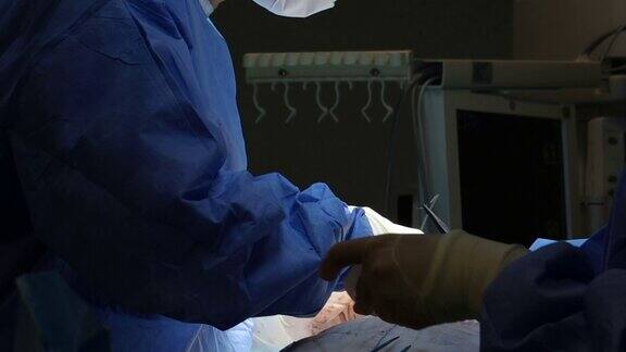 4K真实手术团队完成手术外科医生和护士戴着无菌手套用线缝合伤口
