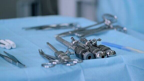 各种类型和用途的医用双极腹腔镜钳(剪)在手术室的新样品蓝色桌子上的腹腔镜剪刀和钳子